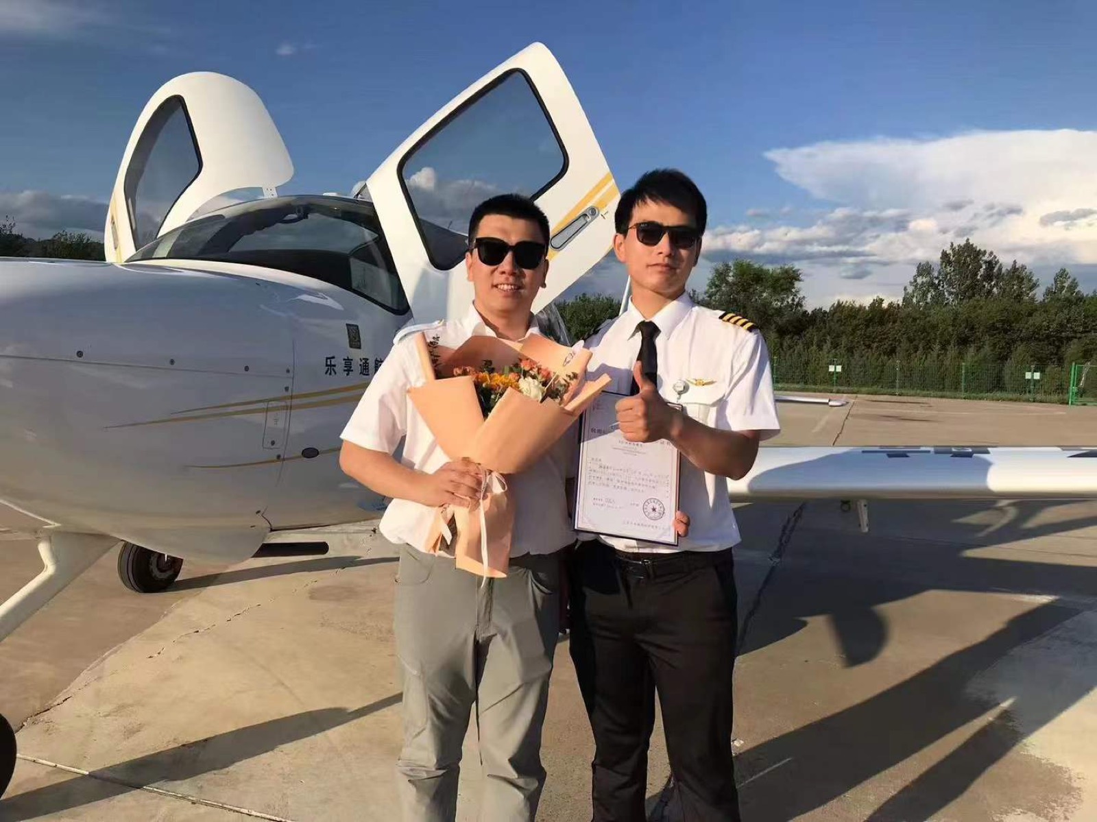 完成飞行训练后与教员在飞机前合影